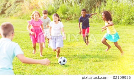 Boys and girls playing football outdoors Boys and girls playing football outdoors 82109936