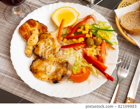 Oven baked hake with vegetable garnish Oven baked hake with vegetable garnish 82109983