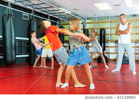 Kids in pair exercising self-defense movements Kids in pair exercising self-defense movements 82110005