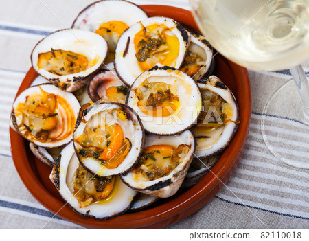 Baked in oven with sauce open seashell served at white plate 82110018
