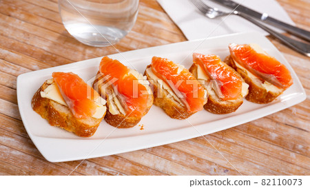 Smoked salmon with butter on bread slice, in natural light, authentic food. 82110073