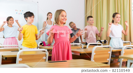 Small school kids doing physical exercises with teacher 82110549