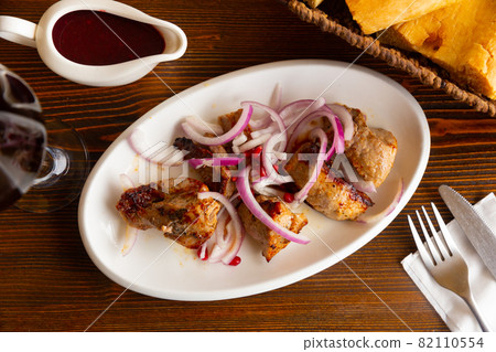 Grilled pork meat shashlik with sliced onion 82110554