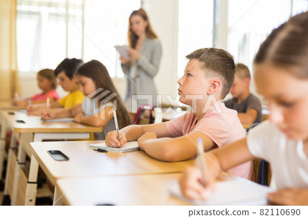 Schoolboy sitting in classroom during lesson in elementary school Schoolboy sitting in classroom during lesson in elementary school 82110690