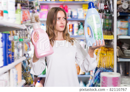 Young woman holding two bottles of rinse aid 82110767