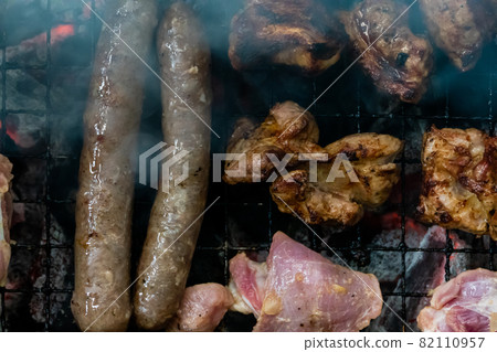 Top view of sausage and meat grilling on barbecue 82110957