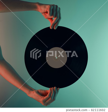Woman hold retro vinyl disc in hands, toned photo 82111602