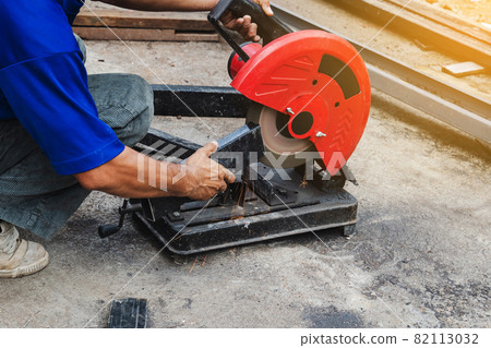 Worker man cutting steel with a circular steel cutter. 82113032
