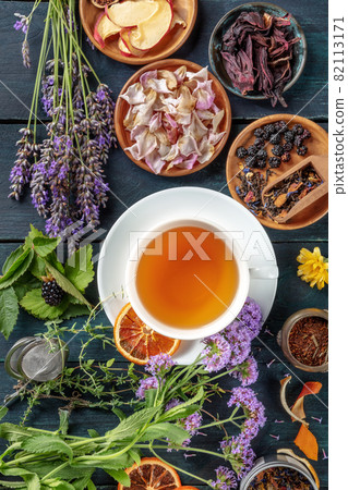 Tea with herbs, flowers and fruit, shot from the top on a wooden background Tea with herbs, flowers and fruit, shot from the top on a wooden background 82113171
