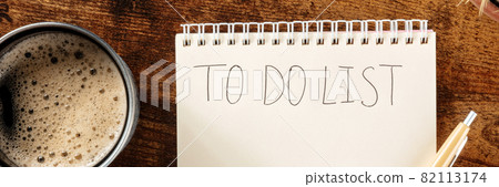 To do list overhead panorama with coffee. A notebook on a wooden desk To do list overhead panorama with coffee. A notebook on a wooden desk 82113174
