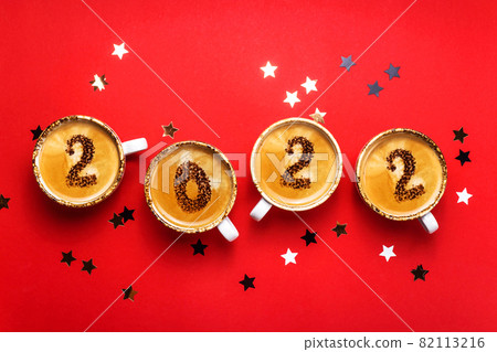 New year 2022 is drawn on cups of coffee on red background 82113216