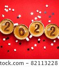 New year 2022 is drawn on cups of coffee on red background 82113228