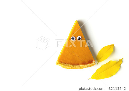 Slice of pumpkin pie in form of Halloween ghost with eyes on white isolated background. Festive creative food concept Slice of pumpkin pie in form of Halloween ghost with eyes on white isolated background. Festive creative food concept 82113242