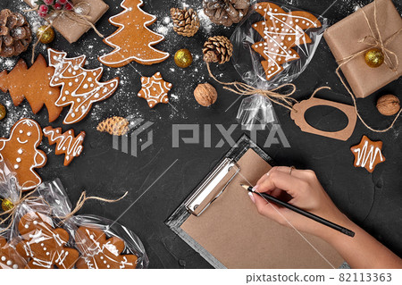 Christmas cookie tree made with star cookie cutter gingerbread new year pastry decorated with rope bow and form for cutting out cookies on black table. 82113363