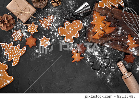 Christmas homemade gingerbread cookies, spices and cutting board on dark background with copy space for text top view. New year and christmas postcard Christmas homemade gingerbread cookies, spices and cutting board on dark background with copy space for text top view. New year and christmas postcard 82113485
