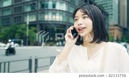 A woman talking on a smartphone A woman talking on a smartphone 82113738