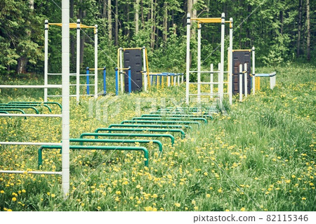 Sports ground with trainers on green lawn with flowers Sports ground with trainers on green lawn with flowers 82115346