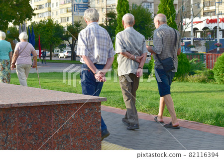Russia. The city of Tambov. In the park. 08/15/2021. Three aged men are walking in the park and talking. Russia. The city of Tambov. In the park. 08/15/2021. Three aged men are walking in the park and talking. 82116394
