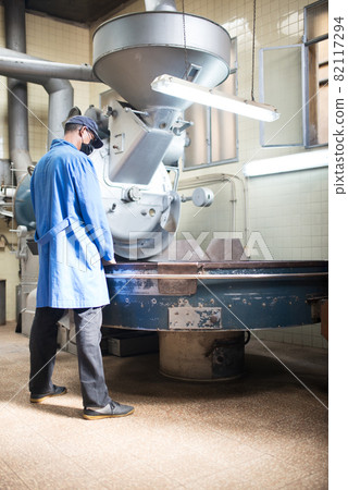 Man standing at roasting machine 82117294