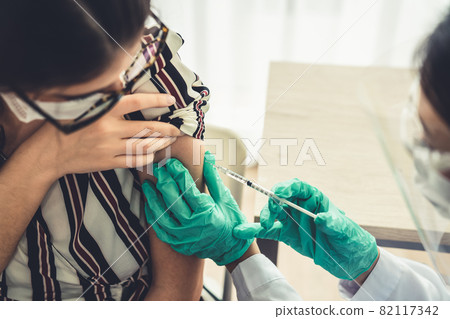 Young woman visits skillful doctor at hospital for vaccination Young woman visits skillful doctor at hospital for vaccination 82117342