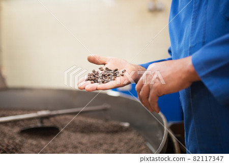Close-up of man holding roasted coffee beans Close-up of man holding roasted coffee beans 82117347