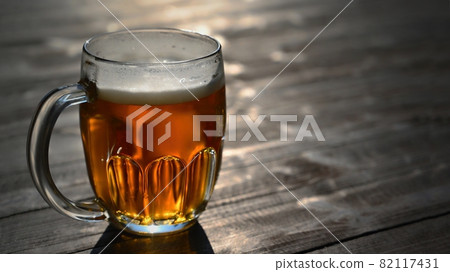 Refreshing fresh draft beer in a dewy glass. Good and honest Czech quality beer on a wooden table background. 82117431