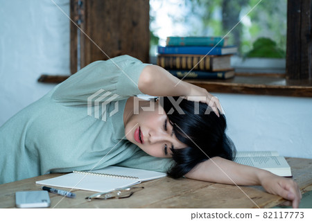 Young woman sleeping tired of studying Young woman sleeping tired of studying 82117773
