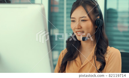 Businesswoman wearing headset working actively in office Businesswoman wearing headset working actively in office 82119714