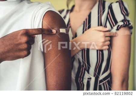 Diverse group of people showing COVID-19 vaccine bandage merrily Diverse group of people showing COVID-19 vaccine bandage merrily 82119802