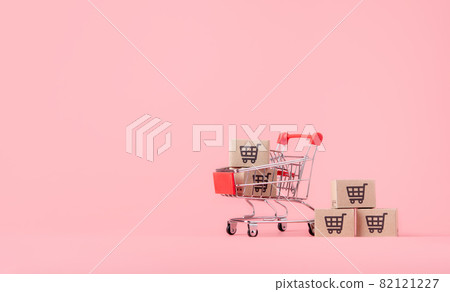 Shopping concept : Cartons or Paper boxes in red shopping cart on pink background. online shopping consumers can shop from home and delivery service. with copy space Shopping concept : Cartons or Paper boxes in red shopping cart on pink background. online shopping consumers can shop from home and delivery service. with copy space 82121227