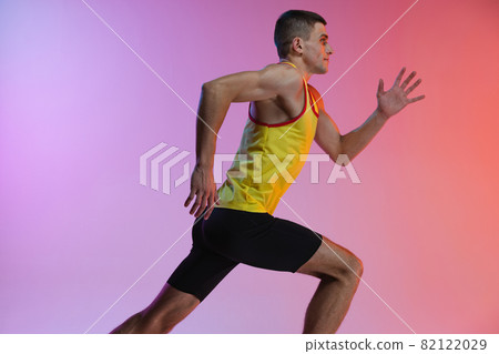 Cropped side view image of male athlete in motion isolated over gradient studio background. Cropped side view image of male athlete in motion isolated over gradient studio background. 82122029