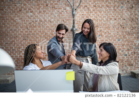 Cheerful young and old businesspeople celebrating success in office, cooperation concept. Cheerful young and old businesspeople celebrating success in office, cooperation concept. 82122136