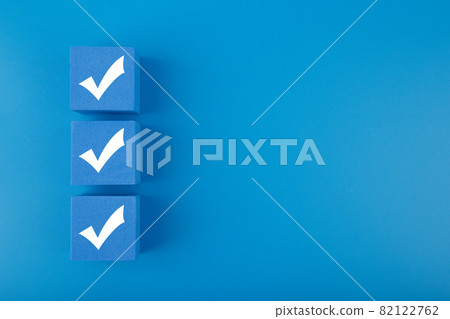 Three checkmarks on blue cubes against blue background with copy space Three checkmarks on blue cubes against blue background with copy space 82122762