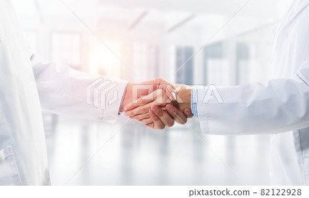 Close-up of the handshake between the two medics. Against the backdrop of the cityscape Close-up of the handshake between the two medics. Against the backdrop of the cityscape 82122928