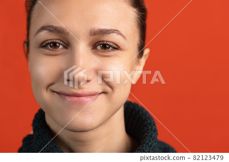 Close-up portrait of young bautiful caucasian girl isolated over red studio background. Smiling Close-up portrait of young bautiful caucasian girl isolated over red studio background. Smiling 82123479