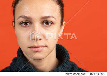 Close-up portrait of young bautiful caucasian girl isolated over red studio background Close-up portrait of young bautiful caucasian girl isolated over red studio background 82123488