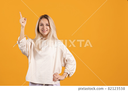 One beautiful caucasian girl posing isolated over yellow background One beautiful caucasian girl posing isolated over yellow background 82123538