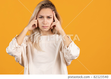 Thoughtful beautiful caucasian girl posing isolated over yellow background Thoughtful beautiful caucasian girl posing isolated over yellow background 82123540
