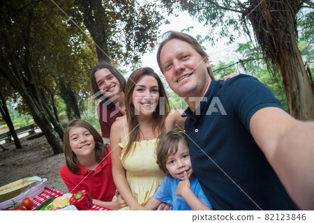 Happy family taking selfie at picnic 82123846