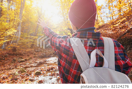 Woman hiking looking at scenic view of autumn foliage landscape. Woman hiking looking at scenic view of autumn foliage landscape. 82124276