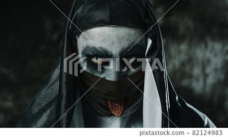 evil nun sticking out her tongue through her mask 82124983