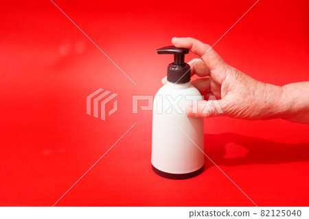 Woman push liquid soap squeezed out to hand. 82125040