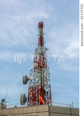 Large telecommunication tower against sky and clouds in background Large telecommunication tower against sky and clouds in background 82125783
