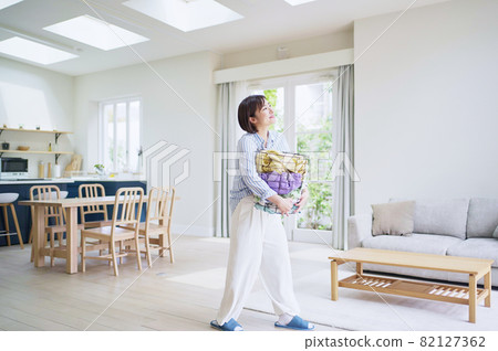 Young woman with laundry basket 82127362
