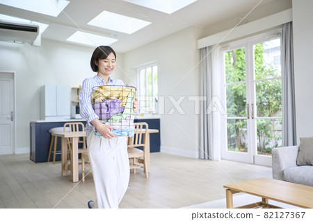 Young woman with laundry basket 82127367