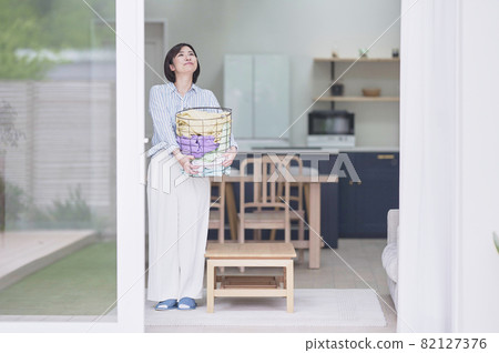 Young woman with laundry basket Young woman with laundry basket 82127376