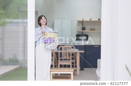 Young woman with laundry basket 82127377