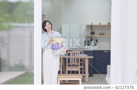 Young woman with laundry basket 82127378