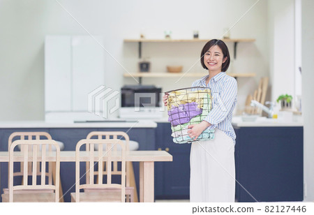 Young woman with laundry basket Young woman with laundry basket 82127446