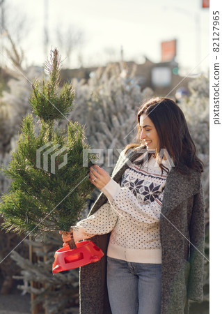 Cute brunette in a white sweater with Christmas tree 82127965